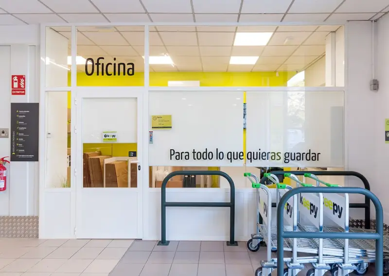 Acceso a la oficina con el lema Para todo lo que quieras guardar y carros de transporte en Keepy Estepona