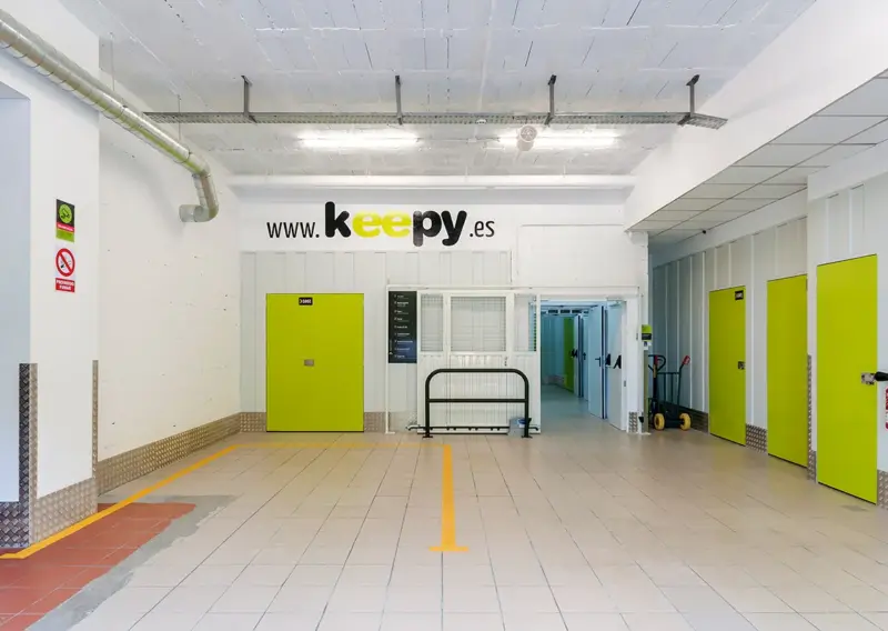 Zona de carga interior con puertas de trastero y el rótulo www.keepy.es en Estepona
