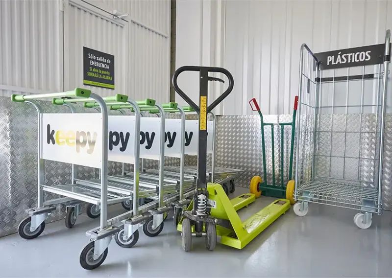 Carros de transporte y transpaleta aparcados junto a la zona de plásticos en Keepy La Huertecilla, Málaga