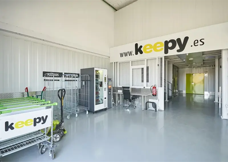 Zona de carros de transporte, máquina expendedora y puesto de trabajo en Keepy La Huertecilla, Málaga