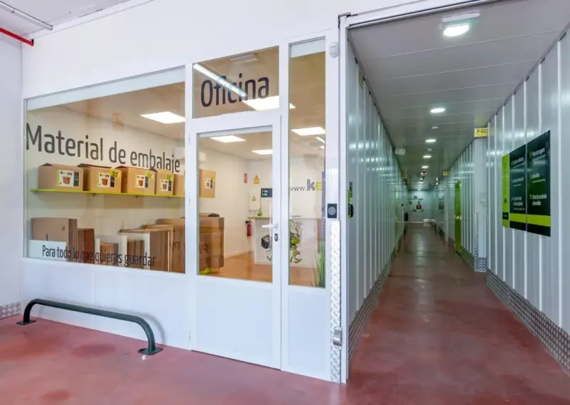 Pasillo junto a la oficina acristalada y el expositor de material de embalaje en Keepy Marbella