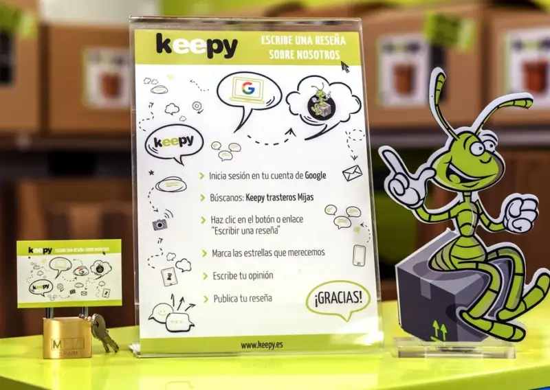 Expositor para dejar reseña en Google sobre el mostrador, junto a un candado y sus llaves, en Keepy Mijas