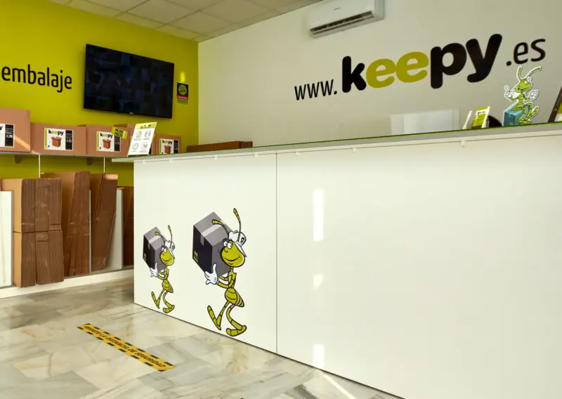 Mostrador de recepción sobre suelo de mármol con la señalización de distancia de seguridad en Keepy Sevilla