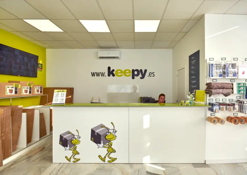Recepción con expositor de accesorios de embalaje y monitor informativo en Keepy Sevilla