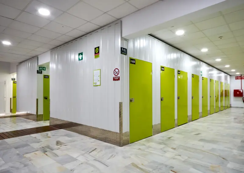 Bloque de trasteros con puertas verdes en un pasillo ancho del centro Keepy de Sevilla