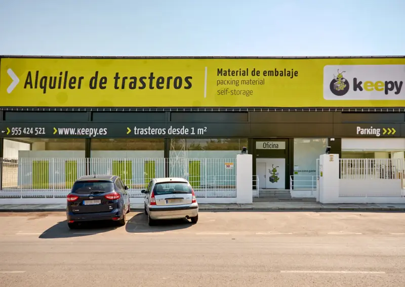 Fachada frontal del centro Keepy de Sevilla con el parking y coches aparcados