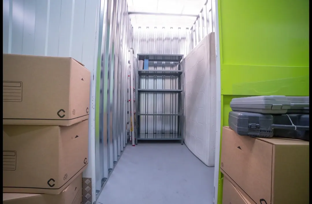 Interior de un trastero Keepy de 3 m² con pasillo central y estanterías al fondo