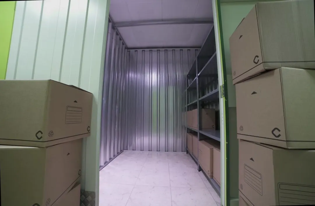 Interior de un trastero Keepy de 4 m² con estanterías a ambos lados y cajas